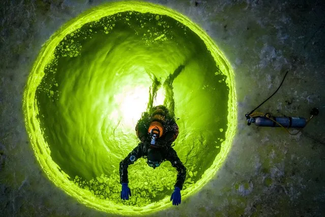 A scuba diver during an ice diving class at the Sea Frogs scuba diving center in the Russian Far Eastern city of Vladivostok, Russia  on January 30, 2022. The air temperature is –11°C (12.2°F), the water temperature is –2°C (28.4°F). Scuba divers undergo theoretical and practical training in ice diving and perform dives in the open water during the day and the night time as part of the Ice Diver NDL special program. (Photo by Yuri Smityuk/TASS)