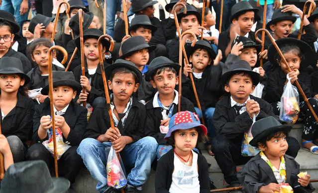 In this photograph taken on April 16, 2018, young Charlie Chaplin impersonators pose for a picture during an event commemorating the legendary actor' s 129 th brithday in Adipur, some 60 km northwest of Bhuj in the western Indian state of Gujarat Wearing bowler hats and fake moustaches while carrying walking sticks, hundreds of Charlie Chaplin fans shuffled bow- legged through a small Indian town to celebrate the comic actor' s birthday this week. (Photo by  Indranil Mukherjee/AFP Photo)