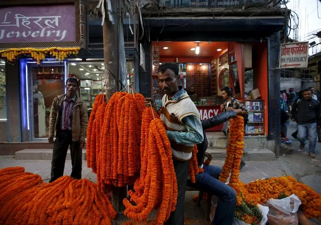 A vendor (C) sells garlands along the streets of Kathmandu during the Tihar festival, also called Diwali, in Kathmandu, Nepal, November 10, 2015. (Photo by Navesh Chitrakar/Reuters)