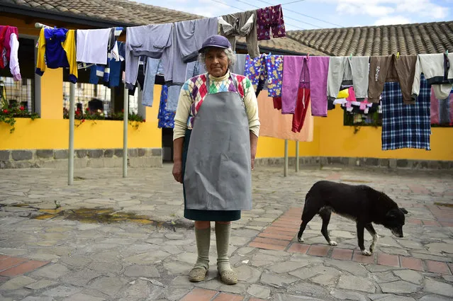 Ecuadorean washerwoman Delia Veloz, 74, is pictured next to clothes hang- drying at the municipal laundry of the Ermita neighborhood, in Quito, on March 5, 2018. Veloz has been a washerwoman for over 50 years and earns around four dollars a day. (Photo by Rodrigo Buendia/AFP Photo)