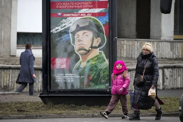 People walk past an army recruiting billboard with the words “Military service under contract in the armed forces” in St. Petersburg, Russia, Friday, March 24, 2023. (Photo by AP Photo/Stringer)