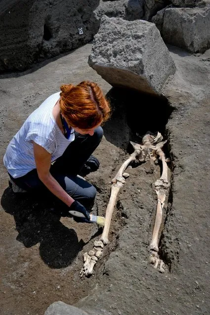 Anthropologist Valeria Amoretti works with a brush on a skeleton of a victim of the eruption of Mt. Vesuvius in A.D. 79, which destroyed the ancient town of Pompeii, at Pompeii' archeological site, near Naples, on Tuesday, May 29, 2018. The skeleton was found during recent excavations and is believed to be of a 35-year-old man with a limp who was hit by a pyroclastic cloud during the eruption. (Photo by Ciro Fusco/ANSA via AP Photo)