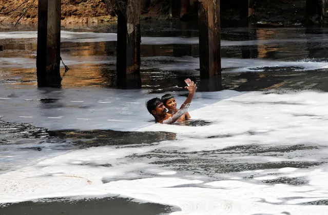 A man and a boy pose for a selfie while swimming in the polluted waters of the Yamuna River on World Environment Day in New Delhi, India, June 5, 2018. (Photo by Saumya Khandelwal/Reuters)