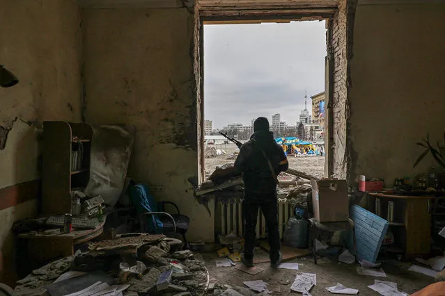 A member of the Territorial Defense Forces of Ukraine stands inside the damaged Kharkiv regional administration building in the aftermath of a shelling in downtown Kharkiv, Ukraine, 01 March 2022. Russian troops entered Ukraine on 24 February prompting the country's president to declare martial law and triggering a series of announcements by Western countries to impose severe economic sanctions on Russia. (Photo by Sergey Kozlov/EPA/EFE)