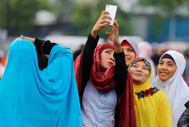 Filipino Muslims take a selfie during the first day celebration of Eid al Fitr before morning prayers at Luneta Park in Manila, Philippines June 15, 2018. (Photo by Erik De Castro/Reuters)