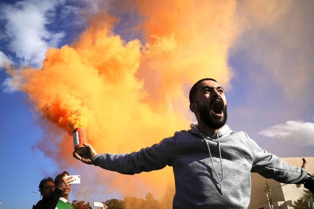 A man waves a flare during a celebratory demonstration following the first Friday prayers since Bashar Assad's ouster, in the central square of Damascus, Syria, December 13, 2024. (Photo by Leo Correa/AP Photo)
