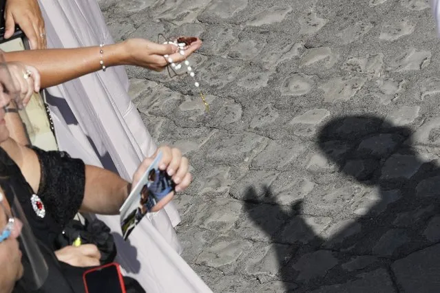 Pope Francis' shadow is cast on the ground as he blesses faithful in the St. Damaso courtyard on the occasion of his weekly general audience at the Vatican, Wednesday, September 16, 2020. (Photo by Gregorio Borgia/AP Photo)