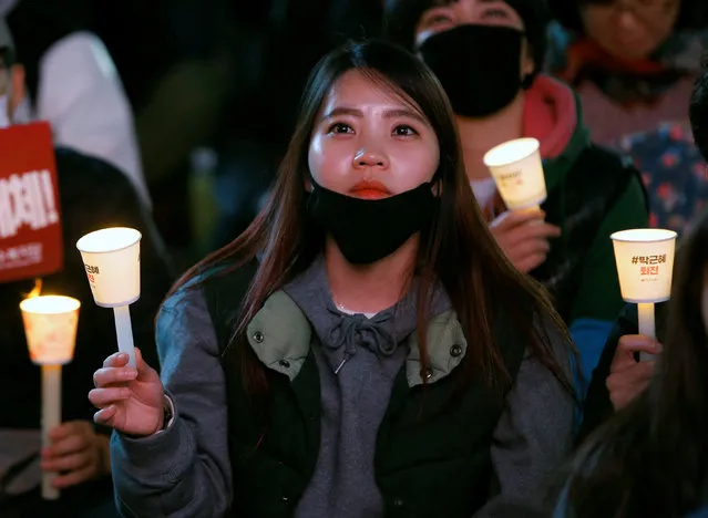 A woman holds a lit candle at a protest calling South Korean President Park Geun-hye to step down, in Seoul, South Korea, November 19, 2016. (Photo by Kim Hong-Ji/Reuters)
