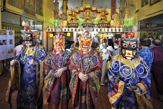 Monks wearing magnificent costumes and masks perform prayers before the Thangka, or traditional painting of Lord Buddha, is unveiled at a Tibetan temple during Wesak day celebration in Ipoh, Malaysia, Thursday, May 4, 2023. Wesak Day, one of the holiest days for Buddhists, offers an opportunity for all followers to come together and celebrate not only Buddha's birthday, but also his enlightenment and achievement of nirvana. (Photo by Vincent Thian/AP Photo)