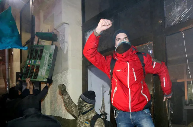 Participants attack a branch of Sberbank during a rally held by activists of nationalist groups and their supporters to mark the anniversary of the 2014 Ukrainian pro-European Union (EU) mass protests on the Day of Dignity and Freedom in Kiev, Ukraine, November 21, 2016. (Photo by Valentyn Ogirenko/Reuters)