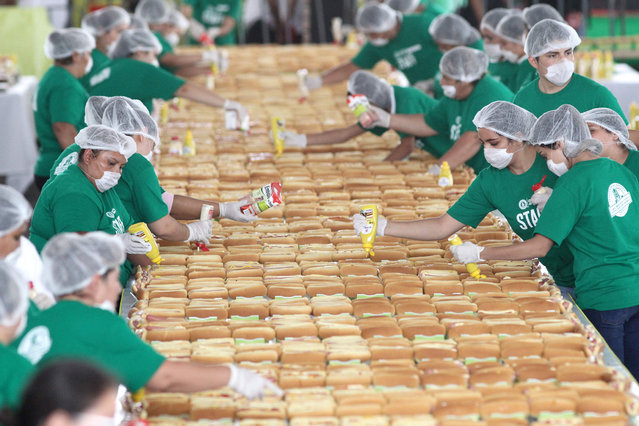 People prepare hundreds of Hot Dogs in an attempt to break the Guinness record of the longest hot dog line in Guadalajara, Jalisco State, on August 12, 2018. Mexico set a Guinness Record by presenting a row of hot- dogs of 1,417 meters long, the largest in the world. (Photo by Ulises Ruiz/AFP Photo)