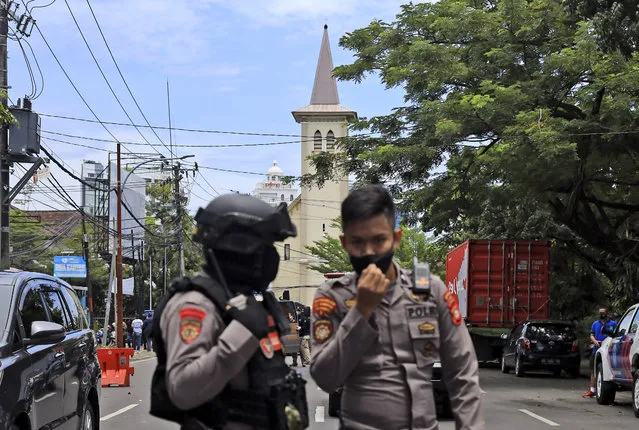 Police officers guard near a church where an explosion went off in Makassar, South Sulawesi, Indonesia, Sunday, March 28, 2021. Police said at least one suicide bomber detonated outside the church on Indonesia's Sulawesi island, wounding several people. (Photo by Yusuf Wahil/AP Photo)