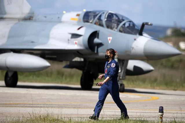 An air force officer walks as a Greek fighter jet Mirage 2000-5 taxis during the international military exercise Iniochos at Andravida air base, about 279 kilometres (174 miles) southwest of Athens, Tuesday, April 20, 2021. Greece vowed Tuesday to expand military cooperation with traditional NATO allies as well as Middle Eastern powers in a race to modernize its armed forces and face its militarily assertive neighbor Turkey. (Photo by Thanassis Stavrakis/AP Photo)