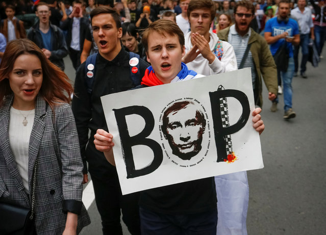 A protester carries a poster reading “Thief” and depicting Russian President Vladimir Putin during a rally against planned increases to the nationwide pension age in St. Petersburg, Russia September 9, 2018. The protests, organized by jailed opposition leader Alexei Navalny and his supporters, were a challenge to the authorities who were hoping for a high turnout at regional elections also being held on Sunday, despite anger over the pension move. (Photo by Anton Vaganov/Reuters)
