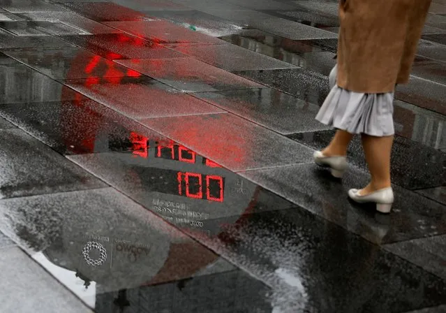 A countdown clock showing that 100 days are left until Tokyo 2020 Olympic Games that have been postponed to 2021 due to the coronavirus disease (COVID-19) pandemic is reflected in a puddle in Tokyo, Japan, April 14, 2021. (Photo by Issei Kato/Reuters)