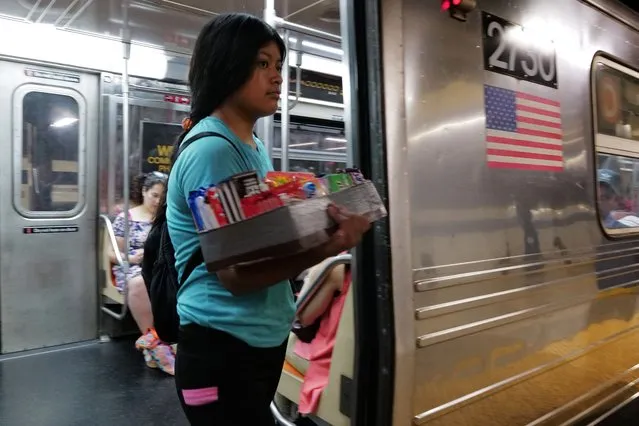 A teenager sells candy and other items in a New York City subway car on August 18, 2023 in New York City. Over 70,000 asylum-seekers have arrived in New York City since last year, according to City Hall, and many have taken to selling items on the streets and subways of the city. Children and young adults selling candy, snacks and drinks in subway stations and cars are an increasingly common site in New York as families look to make ends meet financially as many do not have work permits. (Photo by Spencer Platt/Getty Images)