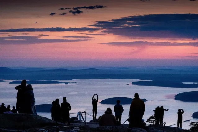 Early-rising visitors to Acadia National Park await the sunrise on the summit of Cadillac Mountain, Sunday, May 16, 2021, near Bar Harbor, Maine. Gov. Janet Mills is is eliminating most outdoor distancing requirements imposed during the COVID-19 pandemic as the tourism season begins to kick into gear. (Photo by Robert F. Bukaty/AP Photo)