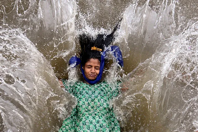 A girl plays in a waterlogged street following a heavy monsoon rainfall in Mumbai on June 9, 2021. (Photo by Sujit Jaiswal/AFP Photo)