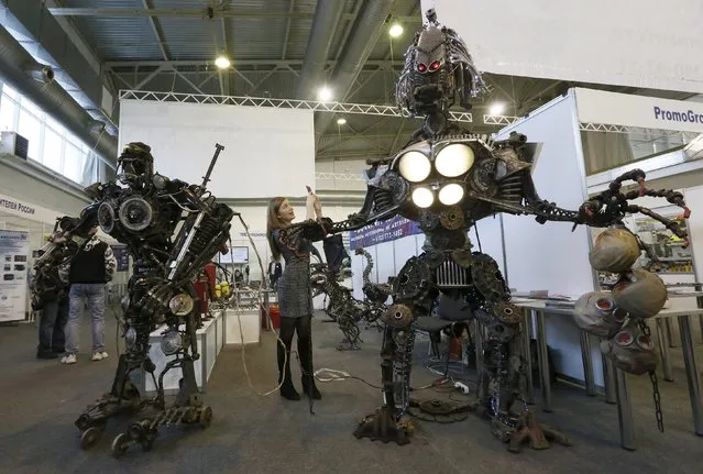 A visitor takes picture of the “Alien Aggressor”, a 3-metre-high electro-mechanical robot made by mechanic and welder Sergei Kulagin (not pictured), during an annual welding and metalwork exhibition in Krasnoyarsk, Russia, February 2, 2016. Kulagin, who works as a mechanic at an automobile service station, created more than a hundred sculptures with used car parts and components during his non-working hours. (Photo by Ilya Naymushin/Reuters)
