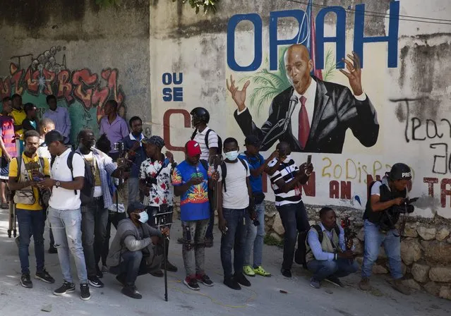 Journalists gather near a mural featuring Haitian President Jovenel Moise, near the leader’s residence where he was killed by gunmen in the early morning hours, and his wife was wounded, in Port-au-Prince, Haiti, Wednesday, July 7, 2021. Claude Joseph, the interim prime minister, confirmed the killing and said the police and military were in control of security in Haiti. (Photo by Joseph Odelyn/AP Photo)