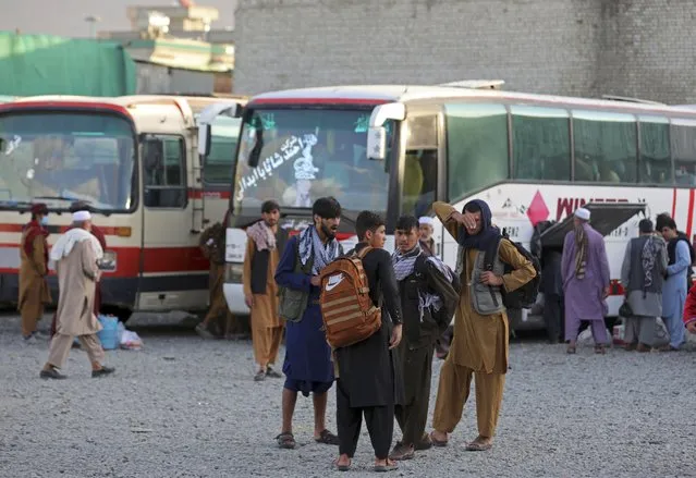 Afghans wait to board a bus to travel to Iran, in Kabul, Afghanistan, Wednesday, June 30, 2021. Frustration and anxiety runs like a theme through most conversations in today’s Afghanistan as Afghans witness the final withdrawal of the U.S. military and its NATO allies. Afghans say international forces are leaving a country deeply impoverished, on the brink of another civil war and with a worsening lawlessness that terrifies some more than the advancing Taliban insurgency. (Photo by Rahmat Gul/AP Photo)