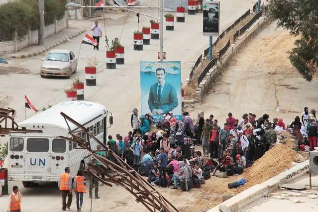 Students wait to cross into the government controlled area of Damascus through a checkpoint controlled by forces loyal to Syria's President Bashar al-Assad in the southern Damascus suburb of Babila May 14, 2015. (Photo by Ward Al-Keswani/Reuters)