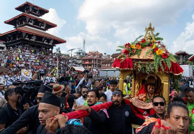 Living god Ganesh is carried on a chariot during Indra Jatra, a festival that marks the end of the rainy season, in Kathmandu, Nepal, Thursday, September 28, 2023. According to a local myth, the god of rain Indra once disguised himself as a human to collect night jasmine for his mother but was captured by locals. In exchange for his release, it was agreed that the rain would be stopped and the souls of those departed in that year ascend to heaven. (Photo by Niranjan Shrestha/AP Photo)
