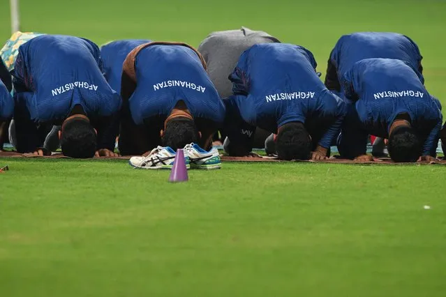 Afghanistan's players offer prayers during a practice session on the eve of their 2023 ICC Men's Cricket World Cup one-day international (ODI) match against Australia at the Wankhede Stadium in Mumbai on November 6, 2023. (Photo by Indranil Mukherjee/AFP Photo)