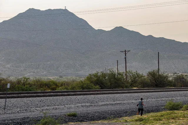 A Guatemalan migrant attempts to enter the United States in Sunland Park, New Mexico after crossing the US-Mexico border on July 22, 2021. Many advocates from national organizations urge President Biden to end Title 42 expulsions, a public health order issued in March 2020 by the Centers for Disease Control and Prevention to prevent the cross-border spread of Covid-19 resulting of hundreds of thousands of migrants expelled within hours of detention and therefore deny the opportunity to state their case for staying in the country. (Photo by Paul Ratje/AFP Photo)