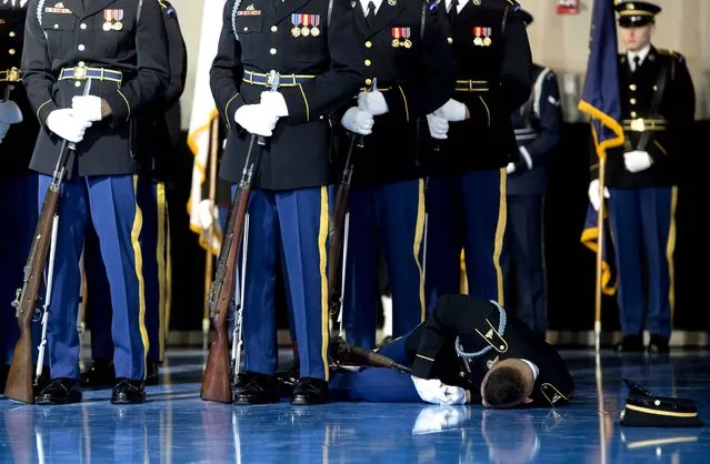 A member of the US Army Honor Guard lays on the floor after passing out during the Armed Forces Full Honor Review Farewell Ceremony for US President Barack Obama at Joint Base Myers- Henderson Hall in Arlington, Virginia, January 4, 2017. (Photo by Saul Loeb/AFP Photo)