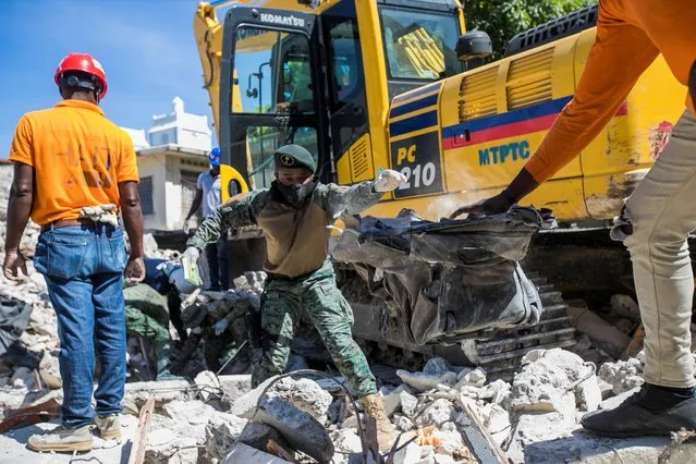 Soldiers and members of a rescue and protection team clean debris from a house after a 7.2 magnitude earthquake in Les Cayes, Haiti on August 15, 2021. (Photo by Ralph Tedy Erol/Reuters)
