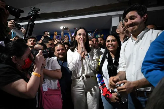 Venezuelan presidential pre-candidate for the opposition Vente Venezuela party, Maria Corina Machado (C) celebrates the results of the opposition's primary elections at her party headquarters in Caracas on October 22, 2023. Venezuela's opposition is voting in primaries that will select a candidate to face President Nicolas Maduro in the elections next year. (Photo by Federico Parra/AFP Photo)