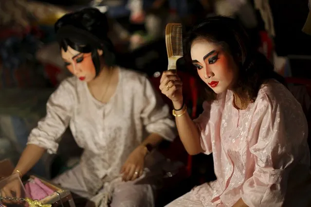 A Chinese opera actress applies make-up backstage before a performance in Chinatown in Bangkok February 17, 2016. In Bangkok's Chinatown, festooned with red lanterns, opera companies perform mythical stories depicting battles and a search for love and justice as celebrations that mark the Lunar New Year come to a close. Thailand is home to the largest overseas Chinese community in the world. (Photo by Jorge Silva/Reuters)