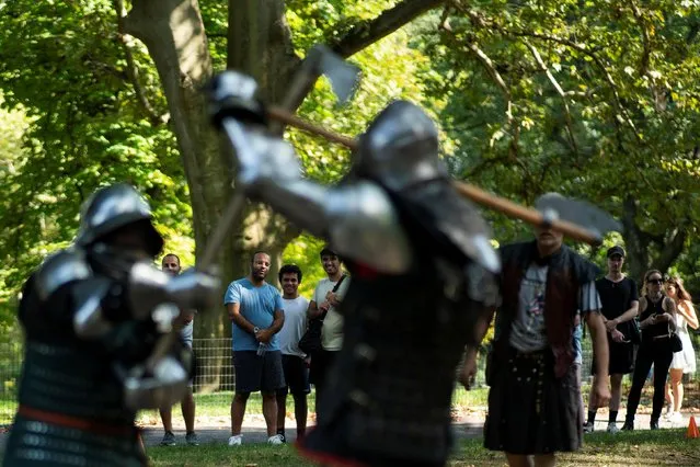 Passersby watch men in full medieval armor taking part in a combat at Central Park in New York, U.S., August 14, 2021. (Photo by Eduardo Munoz/Reuters)