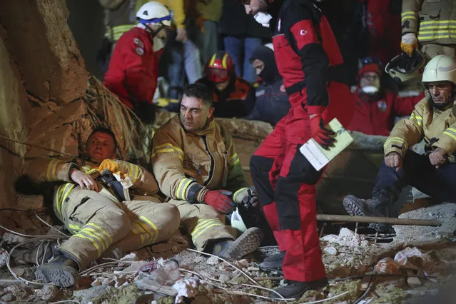 Rescue workers take a break from searching for survivors at the rubble of an eight-story building which collapsed in Istanbul, late Wednesday, February 6, 2019. The eight-story building collapsed, killing at least two people and trapping several others inside the rubble, Turkish officials said. The building had 43 people living in 14 apartments, with a street-level ground floor and seven higher floors, Istanbul Gov. Ali Yerlikaya said, adding that the top three floors had been built illegally.(Photo by Emrah Gurel/AP Photo)