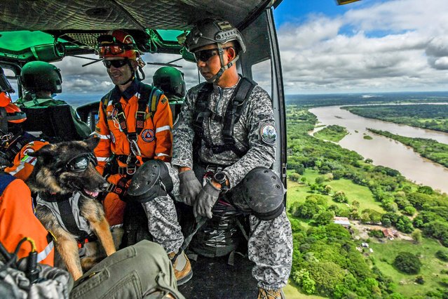 A rescue team flies on a Colombian Air Force helicopter during an earthquake emergency drill with Air Force troops from Colombia, Brazil, Ecuador, Bolivia and the United States at the Palenquero Air Force base in Puerto Salgar, Cundinamarca department, Colombia, on September 2, 2021. Air Force crews from 15 countries take part in the “Angel de los Andes” exercises, where they simulated several rescue operations in different scenarios. (Photo by Joaquin Sarmiento/AFP Photo)