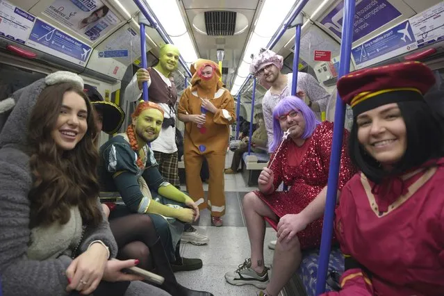Fans pose for a photograph as they take the London Underground to Alexandra Palace to watch the quarterfinals of the World Darts Championship, in London, Monday, January 1, 2024. (Photo by Kin Cheung/AP Photo)