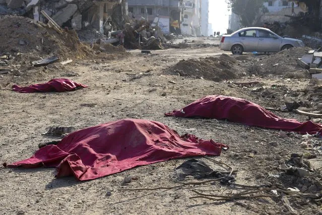 Bodies of Palestinians who were killed in the Israeli bombardment of the Gaza Strip are covered in the main road in Gaza City on Tuesday, January 2, 2024. (Photo by Mohammed Hajjar/AP Photo)
