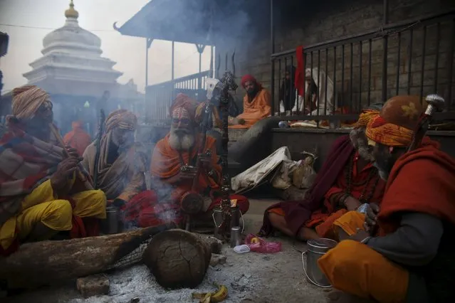 Hindu holy men, or sadhus, sit beside the fire as they chant religious song during the Shivaratri festival at the premises of Pashupatinath Temple in Kathmandu, Nepal, March 7, 2016. (Photo by Navesh Chitrakar/Reuters)