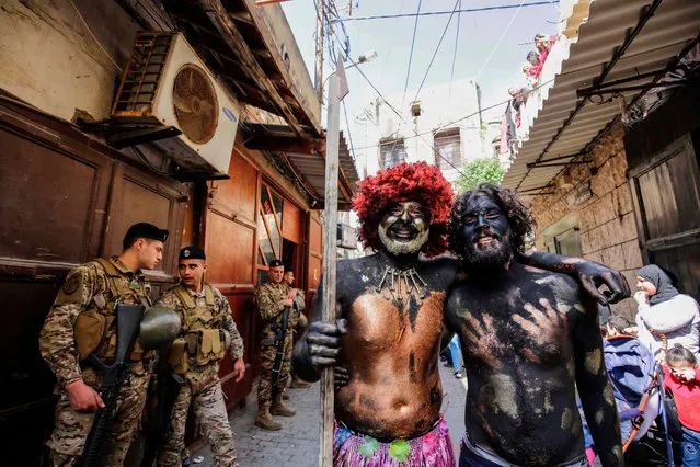 Lebanese men dressed-up in carnival costumes pose for a picture as they take part in the Zambo carnival held in the northern Lebanese port city of Tripoli on March 10, 2019, marking the last period of excess on the eve of the Christian Greek Orthodox lent. The inspiration for the annual Zambo celebration is unclear, despite it being a tradition that stretches back over a century to when an emigrant to Brazil returned to his native Tripoli bringing the carnival with him. (Photo by Ibrahim Chalhoub/AFP Photo)