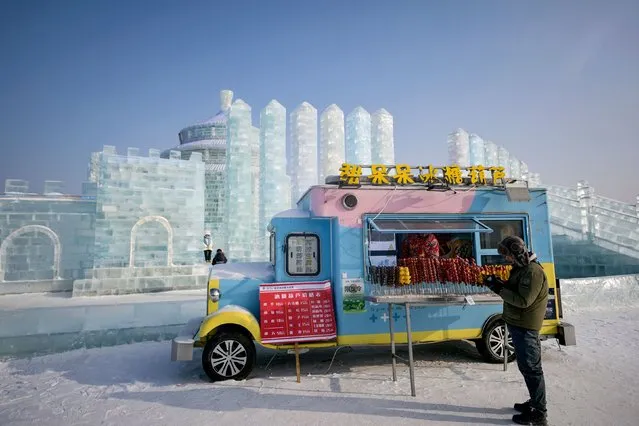 A man stands beside a food van at the Harbin Ice and Snow World in Harbin, in China’s northern Heilongjiang province on January 5, 2024. (Photo by Pedro Pardo/AFP Photo)