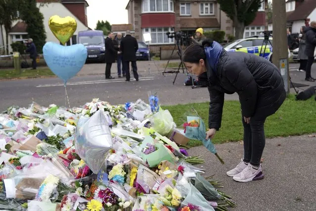A woman places flowers near the Belfairs Methodist Church in Eastwood Road North, where member of Parliament David Amess died after he was stabbed several times on Friday, in Leigh-on-Sea, Essex, England, Sunday, October 17, 2021. The slaying Friday of the 69-year-old Conservative lawmaker Amess during his regular weekly meeting with local voters has caused shock and anxiety across Britain's political spectrum, just five years after Labour Party lawmaker Jo Cox was murdered by a far-right extremist in her small-town constituency. (Photo by Kirsty O'Connor/PA Wire via AP Photo)