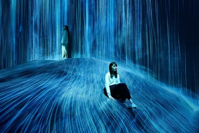 A member of the media sits in a newly unveiled artwork during a press preview of the entire unveiling of “teamLab Borderless” at Azabudai Hills in Tokyo, Japan, 05 February 2024. Relocated from the Odaiba district, the Mori Building Digital Art Museum (teamLab Borderless) consisting in over 50 independent artworks, will open to the public on 09 February 2024. (Photo by Franck Robichon/EPA/EFE)