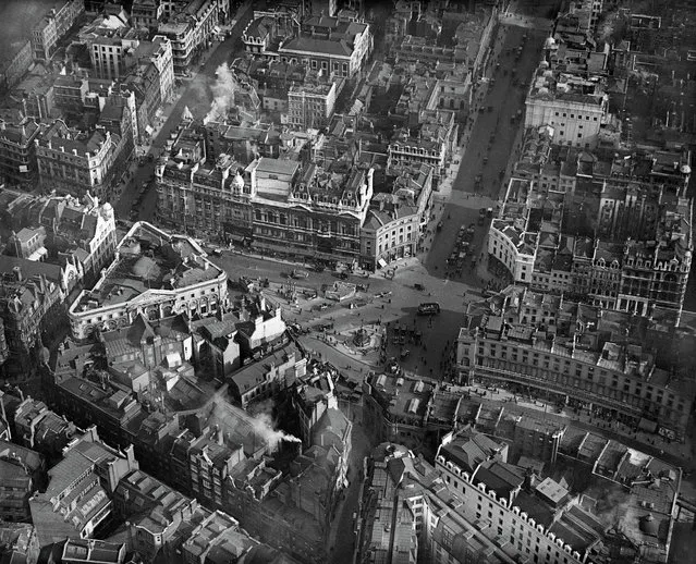 Piccadilly Circus, Westminster. Pictured here in March 1921 – before the installation of any traffic lights – Piccadilly Circus is a busy throng of pedestrians, horsedrawn carriages, omnibuses and motorcars, all revolving around the aluminium-cast statue of Eros. Even at this fledgling stage in Aerofilms' existence, the company was targeting wellknown sites and landmarks to sell to postcard manufacturers