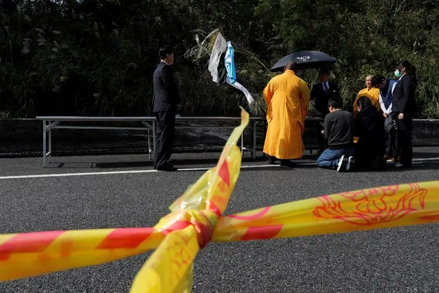 Family members of the passengers on the crashed tour bus pray during a Taoist ceremony for the victims, on a highway in Taipei, Taiwan February 14, 2017. (Photo by Tyrone Siu/Reuters)