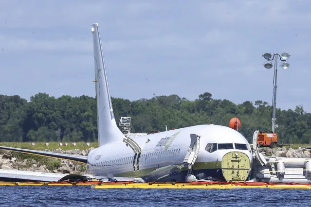 A charter plane carrying 143 people and traveling from Cuba to north Florida sits in a river at the end of a runway, Saturday, May 4, 2019 in Jacksonville, Fla.  The Boeing 737 arriving at Naval Air Station Jacksonville from Naval Station Guantanamo Bay, Cuba, with 136 passengers and seven aircrew slid off the runway Friday night into the St. Johns River, a NAS Jacksonville news release said. (Photo by Gary McCullough/AP Photo)