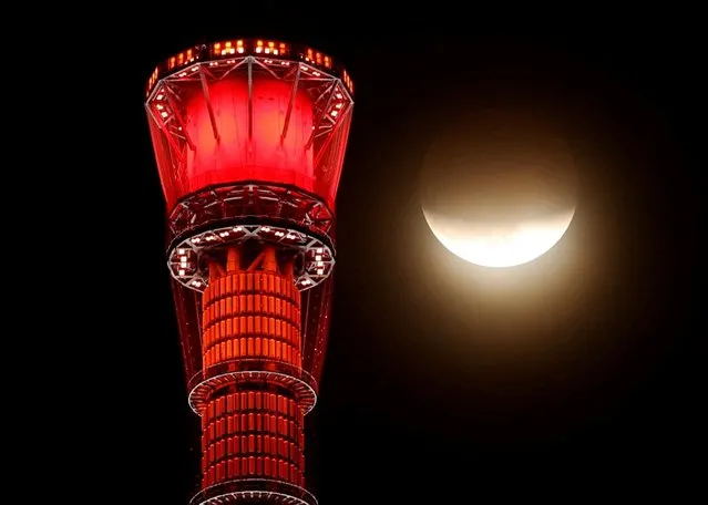 A shadow falls on the moon, as seen beside the world's tallest broadcasting tower Tokyo Skytree, during a partial lunar eclipse in Tokyo, Japan on November 19, 2021. (Photo by Issei Kato/Reuters)