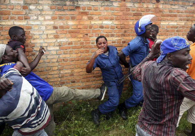 A mob attacks a female police officer accused of shooting a protester in the Buterere neighborhood of Bujumbura, Burundi, May 12, 2015. (Photo by Goran Tomasevic/Reuters)
