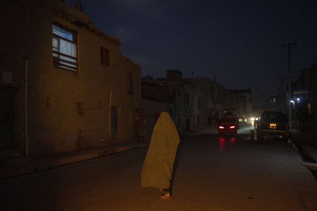A woman wearing a burka walks down a street  in Kabul, Afghanistan, Tuesday, November 16, 2021. (Photo by Petros Giannakouris/AP Photo)