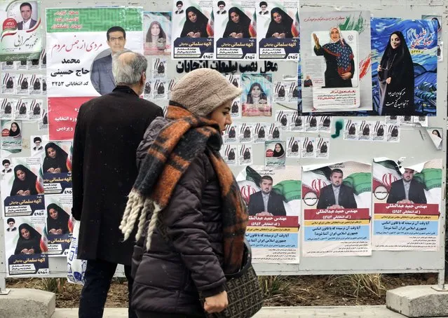Iranians walk next to the electoral posters of candidates running in the upcoming parliamentary elections, in Tehran, Iran, 26 February 2024. Iranians on 01 March 2024 will vote for new members of Iran's parliament, and for the Assembly of Experts, the body in charge of appointing Iran's Supreme Leader. (Photo by Abedin Taherkenareh/EPA/EFE)